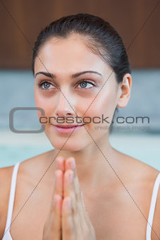 Peaceful woman in white sitting with hands together