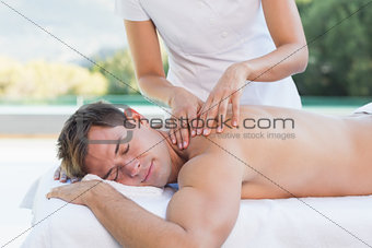 Handsome man getting a massage poolside