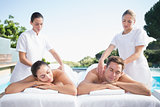Calm couple enjoying couples massage poolside
