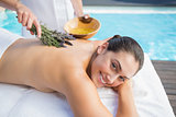 Smiling woman getting an aromatherapy treatment poolside
