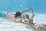 Cute couple kissing underwater in the swimming pool