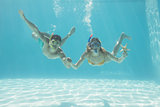 Cute couple underwater in the swimming pool with snorkel and starfish