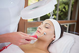 Peaceful brunette getting micro dermabrasion from beauty therapist