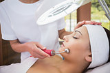 Peaceful brunette getting micro dermabrasion from beauty therapist