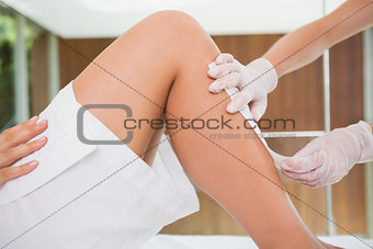 Woman getting her legs waxed by beauty therapist