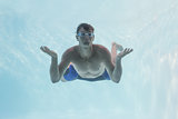 Man shrugging shoulders underwater in swimming pool