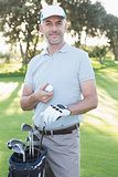 Handsome golfer standing with golf bag