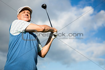 Golfer standing and swinging his club
