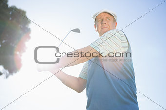 Golfer taking a shot and smiling