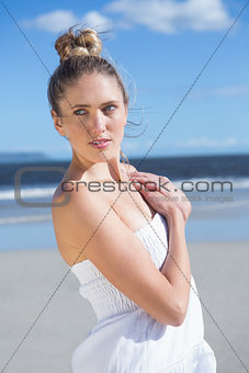 Pretty blonde in white dress posing on the beach