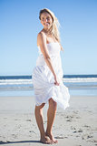 Woman in white dress smiling on the beach