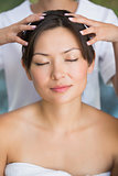 Relaxed brunette getting a head massage
