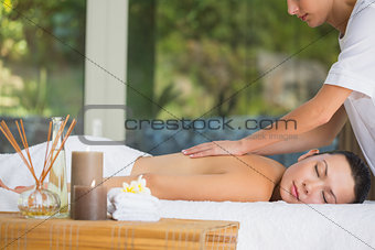 Relaxed brunette getting a back massage