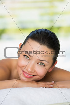 Smiling brunette lying on massage table