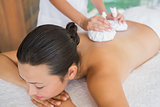 Content brunette getting a herbal compress massage