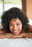 Gorgeous woman lying on massage table smiling at camera