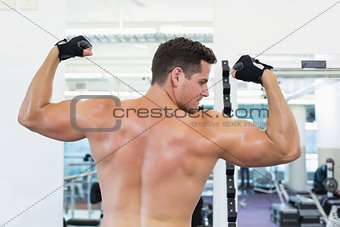 Shirtless bodybuilder flexing his biceps