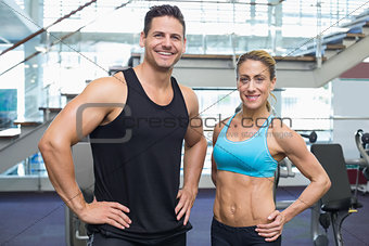Bodybuilding man and woman smiling at camera