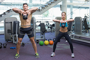Bodybuilding man and woman lifting kettlebells