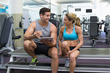 Female bodybuilder sitting with personal trainer talking