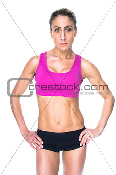 Female bodybuilder posing with hands on hips looking at camera