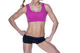 Female bodybuilder posing in pink sports bra and shorts mid section