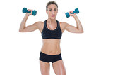 Female bodybuilder holding two dumbbells with arms up