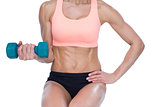 Strong woman doing bicep curl with blue dumbbell