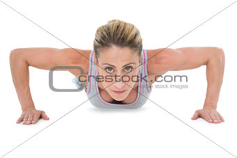 Strong woman doing press ups looking at camera