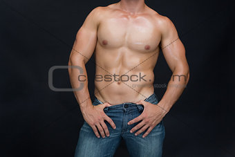 Muscular man posing in blue jeans