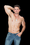 Handsome muscular man posing in blue jeans