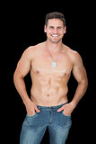 Handsome muscular man posing in blue jeans smiling at camera