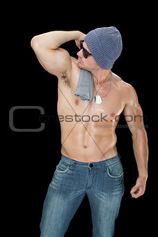 Muscular man posing in blue jeans hat and sunglasses