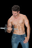 Muscular man lifting dumbbell in blue jeans