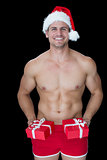 Smiling muscular man posing in sexy santa outfit offering gifts