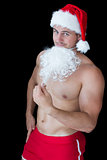 Smiling muscular man posing in sexy santa outfit with fake beard