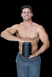 Muscular man posing with nutritional supplement