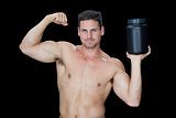 Happy muscular man posing with nutritional supplement