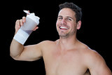 Happy muscular man holding protein drink