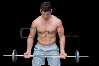 Serious crossfitter lifting up barbell