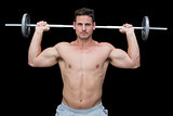 Serious handsome crossfitter lifting up barbell behind head