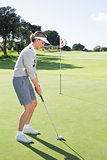 Lady golfer on the putting green at the eighteenth hole
