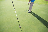 Golfer putting ball on the green