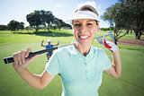 Lady golfer smiling at camera with partner cheering behind