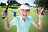 Lady golfer cheering at camera with partner behind
