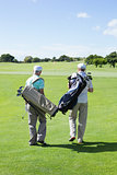 Golfer friends walking and holding their golf bags