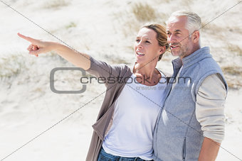 Happy couple on the beach looking at something