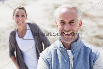 Couple smiling at camera on the beach