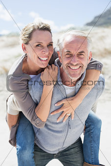Laughing couple smiling at camera on the beach