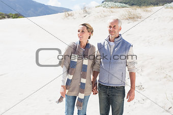 Attractive couple standing holding hands on the beach